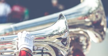 close up photo of person playing horn instrument