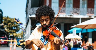 A man playing the violin or fiddle on the streets in New Orleans in the French Quarter