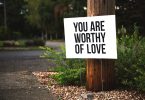 you are worthy of love sign beside tree and road