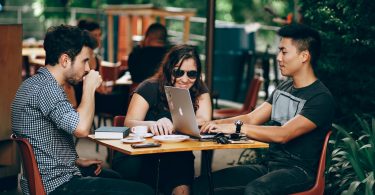 photo of three person sitting and talking