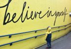 toddler looking at believe in yourself graffiti